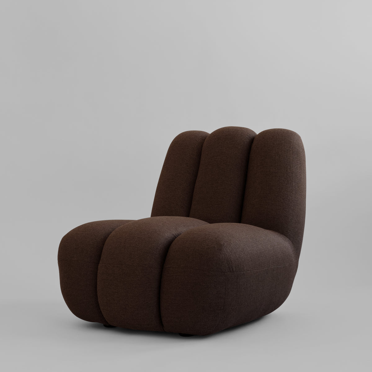 Toe loungestol fra 101 Copenhagen med polstring i mørkebrunt tekstil og lodrette felter.
