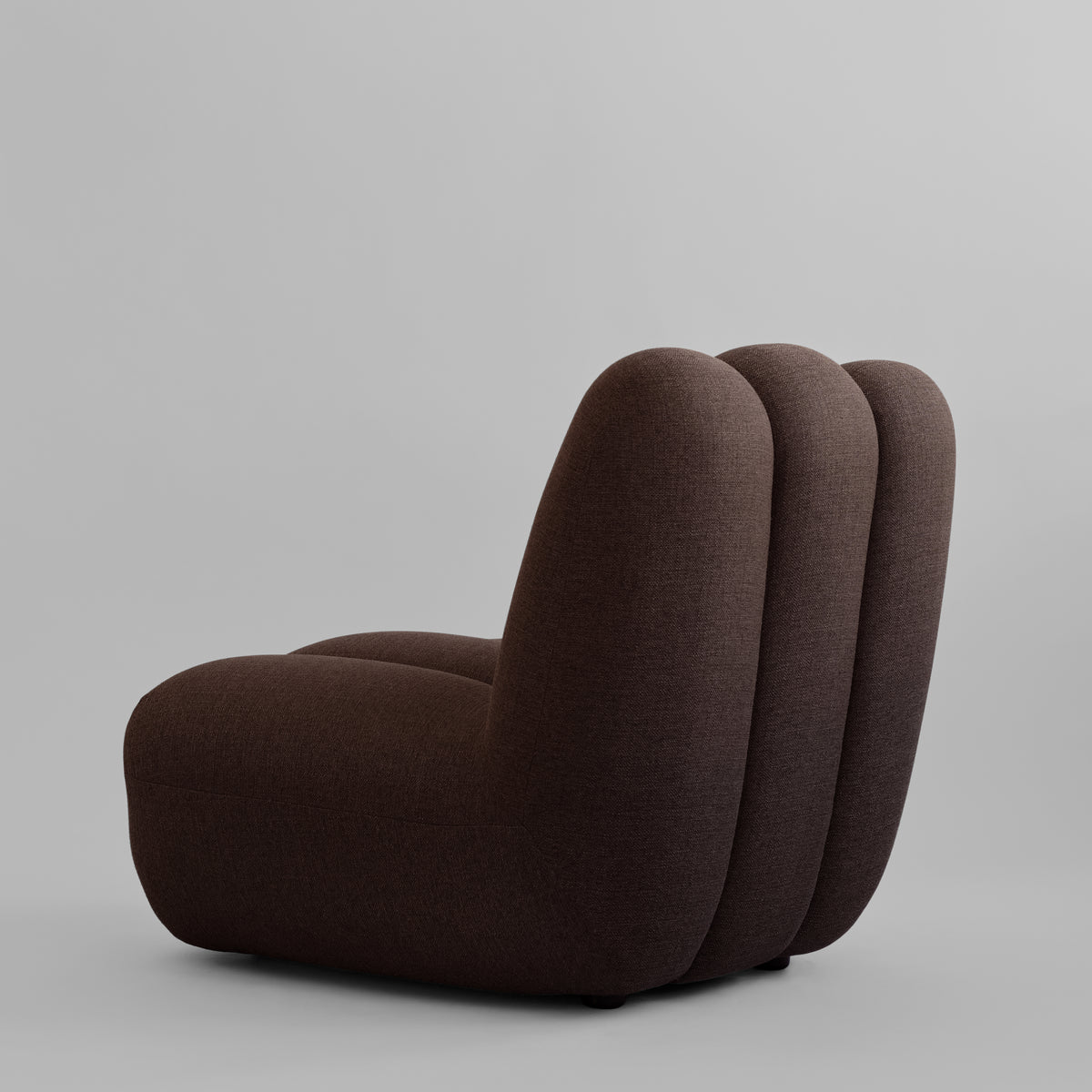 Toe loungestol fra 101 Copenhagen med polstring i mørkebrunt tekstil og lodrette felter.