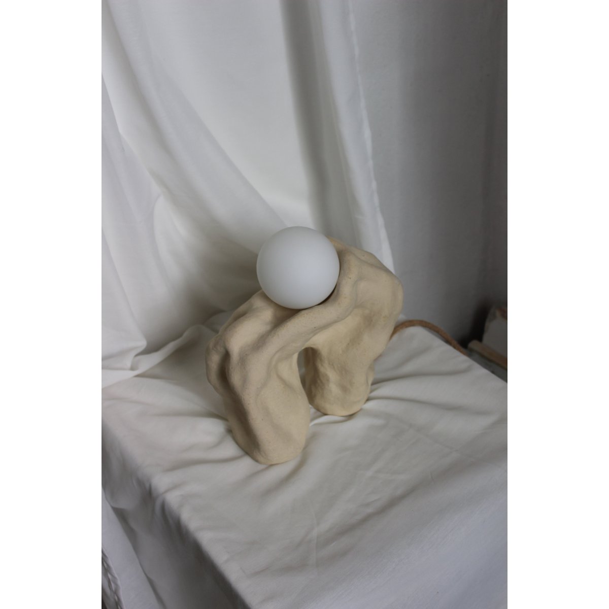 Forma Lamp fra NIWA Ceramics med beige keramisk form, hvid lyskugle og synlig ledning