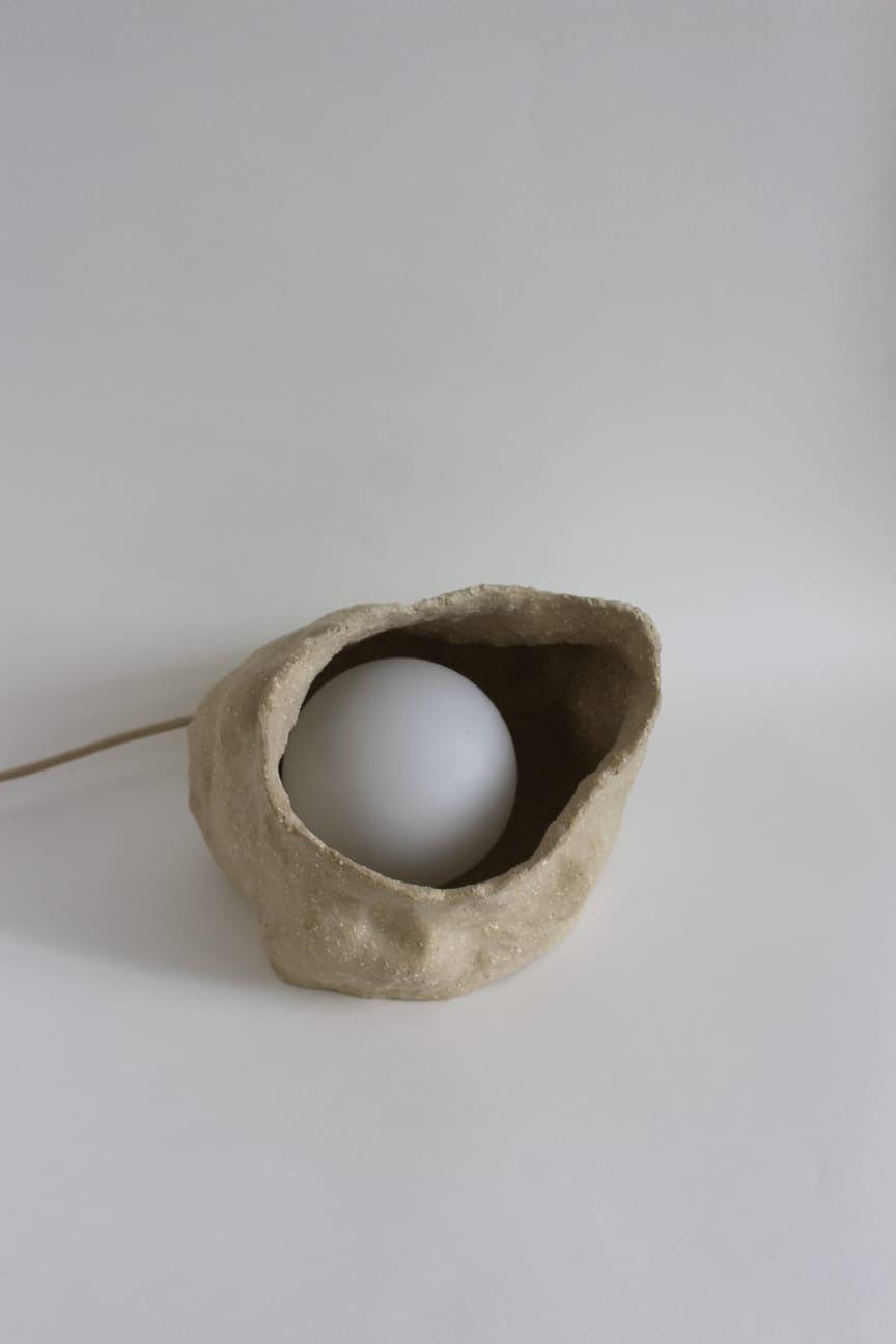 Sand Globe Lamp fra NIWA set skråt ovenfra med den hvide lyskugle i den keramiske base