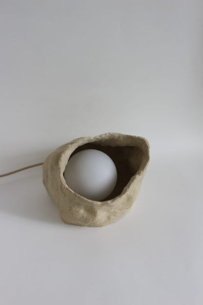 Sand Globe Lamp fra NIWA set skråt ovenfra med den hvide lyskugle i den keramiske base